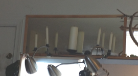 Candles on shelf in front of mirror