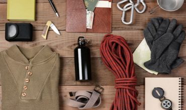 survival gear laid out on wooden background