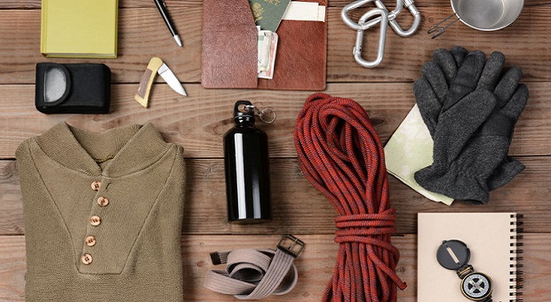 survival gear laid out on wooden background